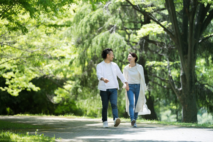 公園を歩くカップルの画像